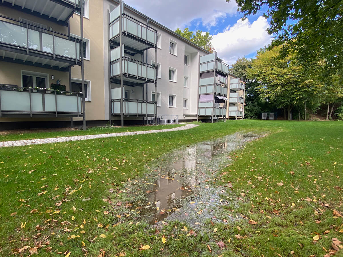 Pfütze auf der Wiese vor dem Gebäude